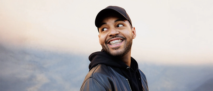 Man With Cap Smiling with Braces on Teeth